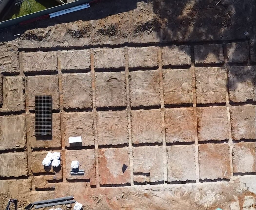 Footing trenches cut in a clean grid, top-down drone view